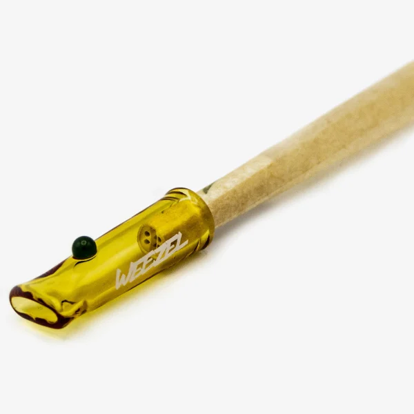 WEEZEL Glas-Tip "Pineapple Kush" in gelb mit grüner Perle, auf einem Joint, von der Seite mit Aktivkohle-Filter von PURIZE, schräge Ansicht